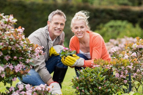 Worker wearing PPE operating a hedge trimmer safely